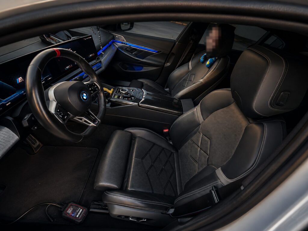 Přední sedadla BMW i5 M60 xDrive a diagnostický přístroj připojený k vozu
