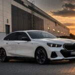 Bílé BMW i5 M60 xDrive G60 zepředu z boku při západu slunce