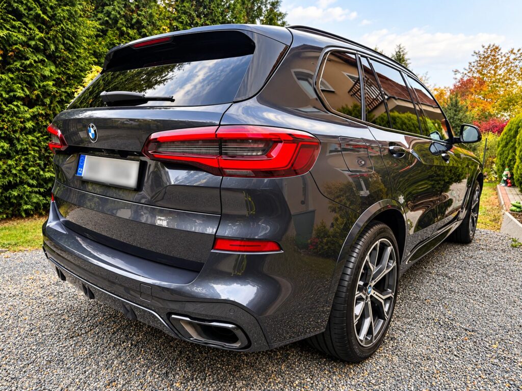Zadní část šedého BMW X5 G05 se svítilnami LED a koncovkami výfuku
