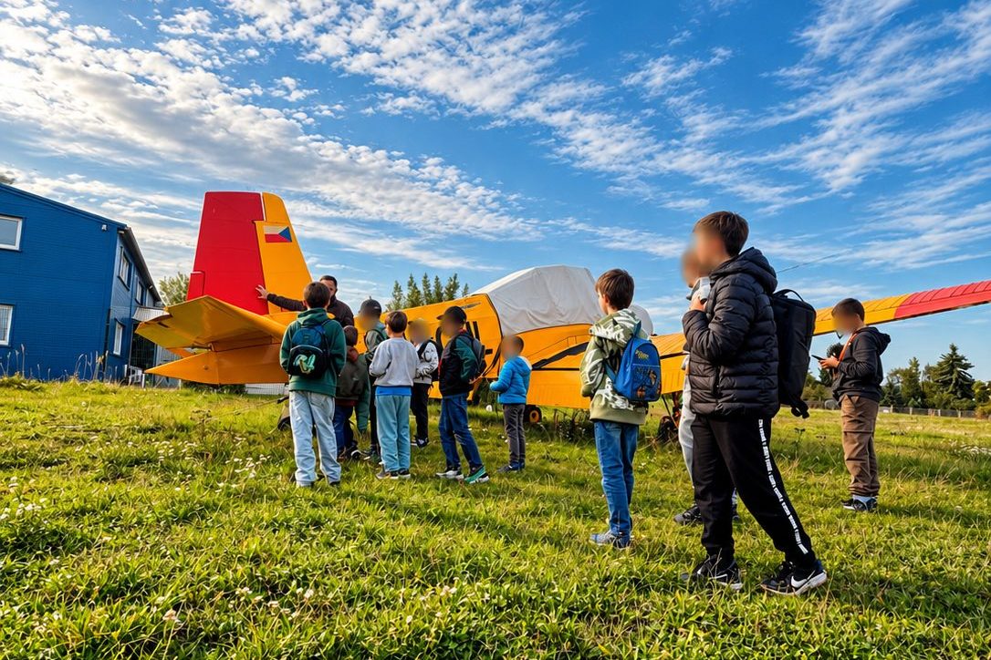 Děti z kroužku Junior Technik u žlutého letadla na travnaté ploše