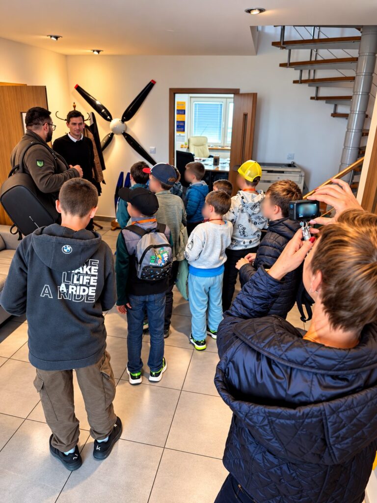 Děti z kroužku Junior Technik v místnosti s leteckou vrtulí na zdi